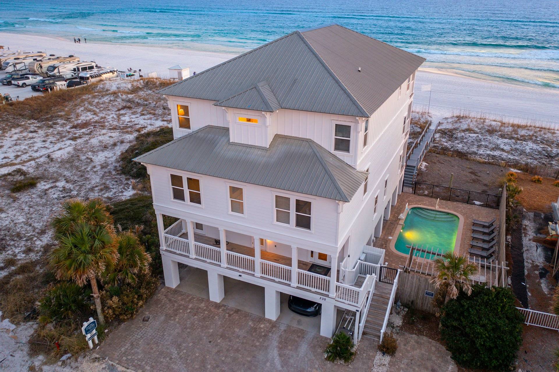 Aerial view of the house, pool, and beach